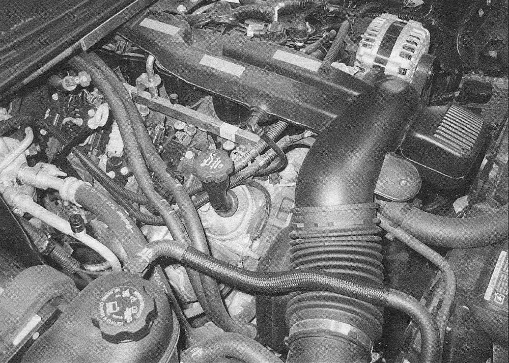 Chevrolet Silverado V8 engines _ The heater hoses can be unclipped from their retainer to remove the right valve cover